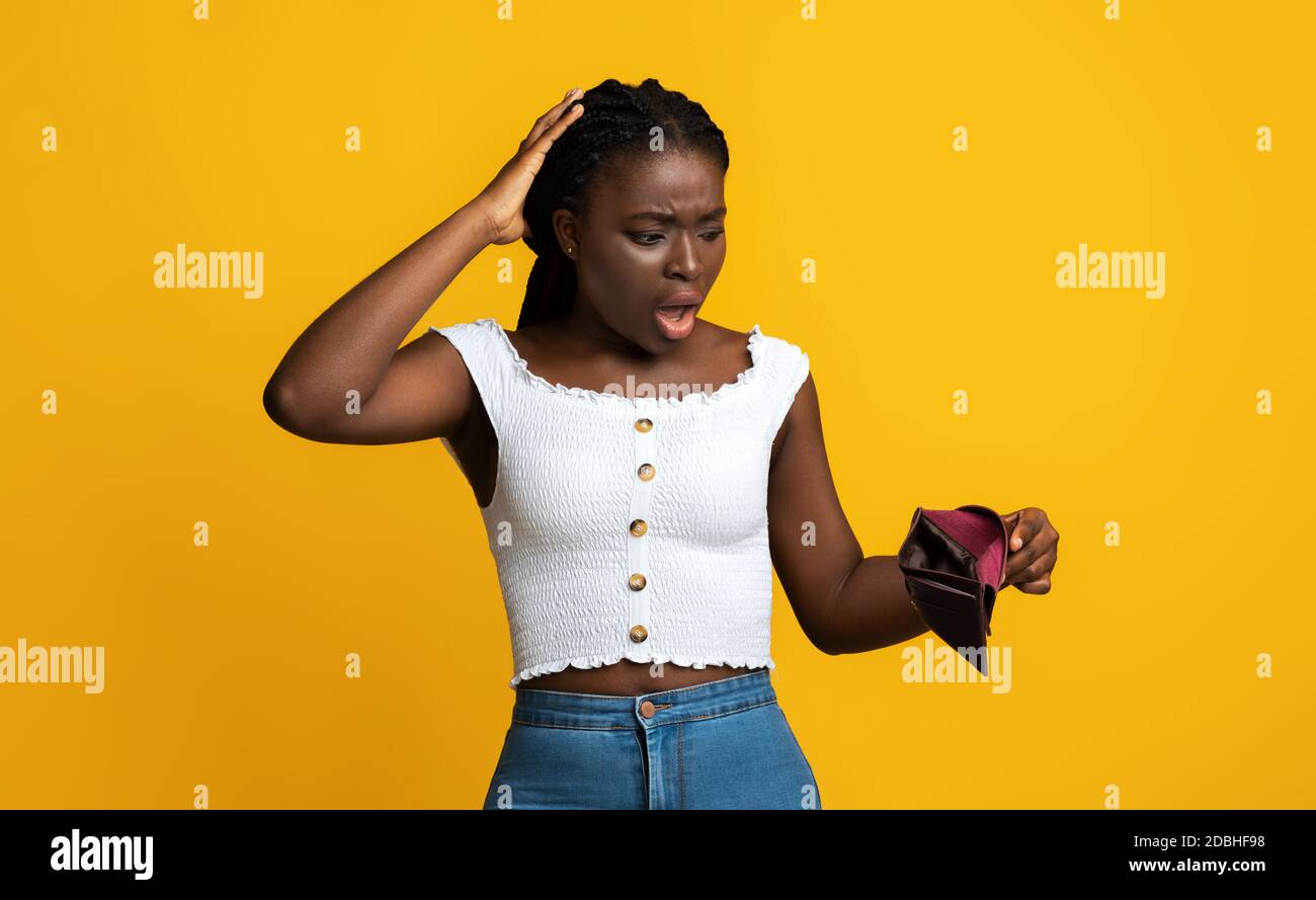 Oh No. Shocked Black Woman Looking At Empty Wallet In Her Hands Stock Photo