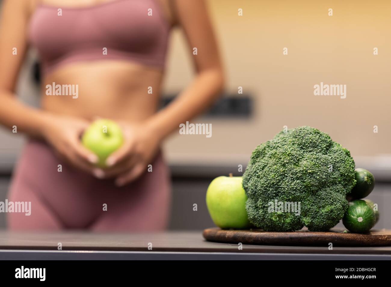 Skinny Girl Dieting Standing In Kitchen, Focus On Vegetables, Cropped Stock Photo
