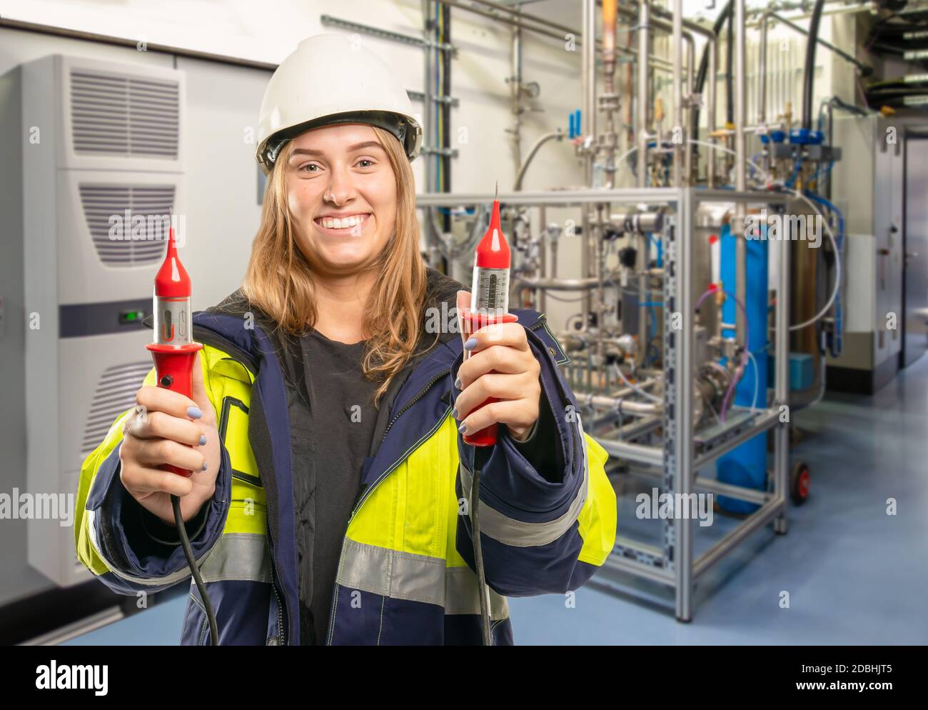 a female electrician in an industrial plant holds up a measuring device  Stock Photo - Alamy