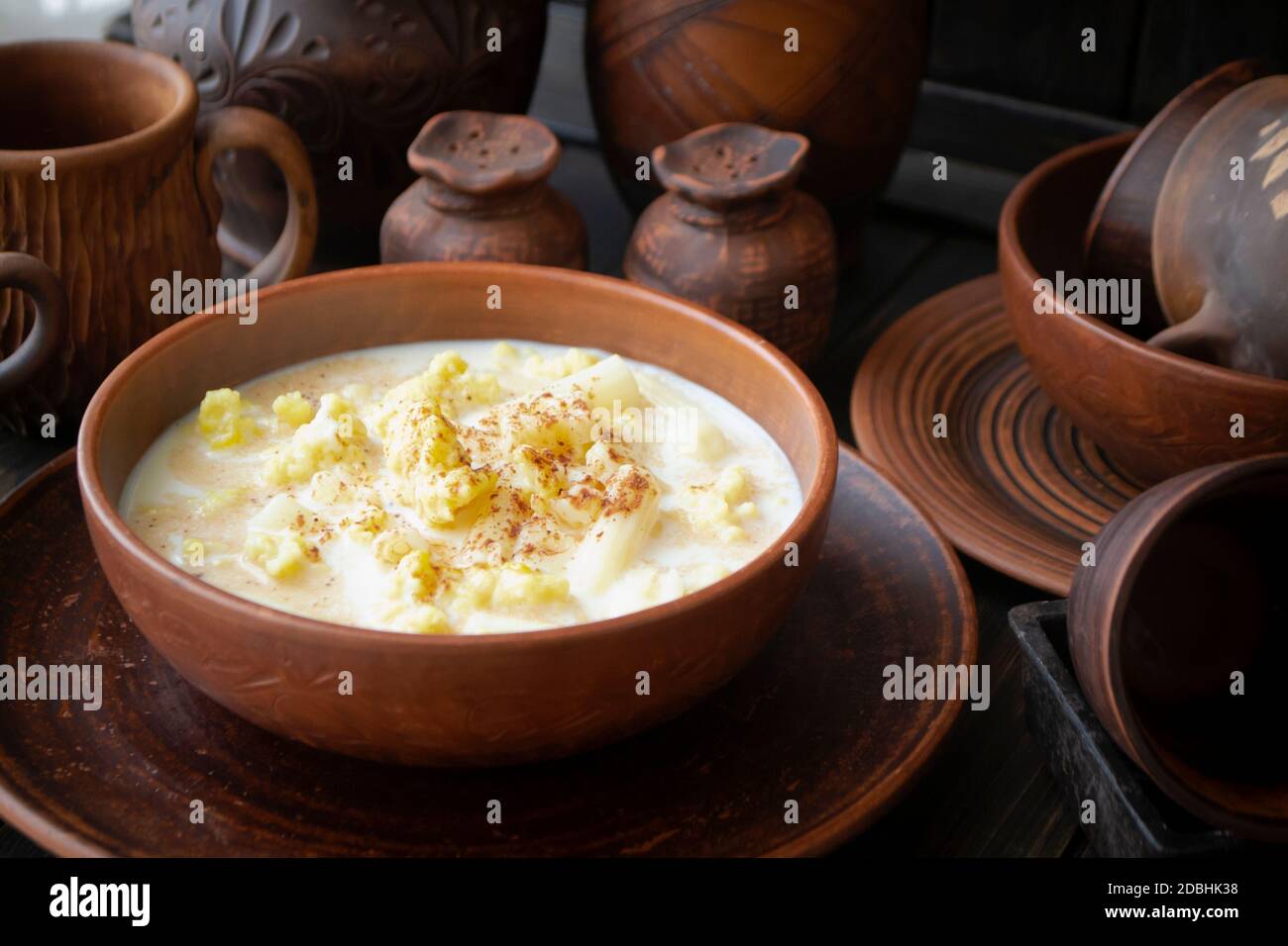 Milk soup with cocoa powder in an old ceramic bowl, dark background Stock Photo