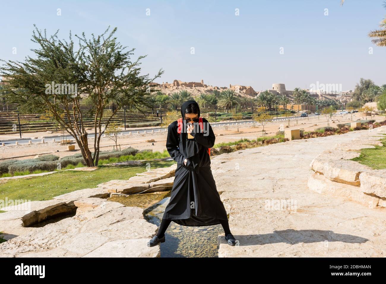 A woman wearing black hijab visiting the ruins of Diraiyah, also as Dereyeh and Dariyya, a town in Riyadh, Saudi Arabia Stock Photo