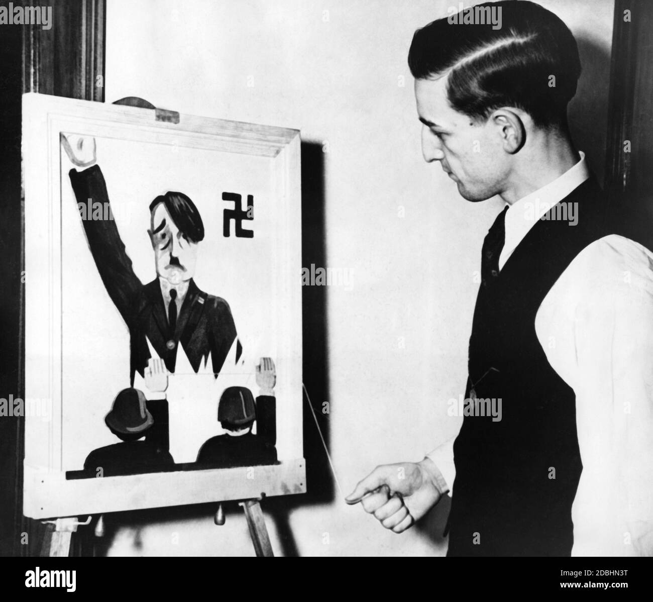 Presentation of a Hitler caricature. The arms of the two listeners can be raised to show the Nazi salute with a string. William Sauter mocks the introduction of the Hitler salute. Stock Photo