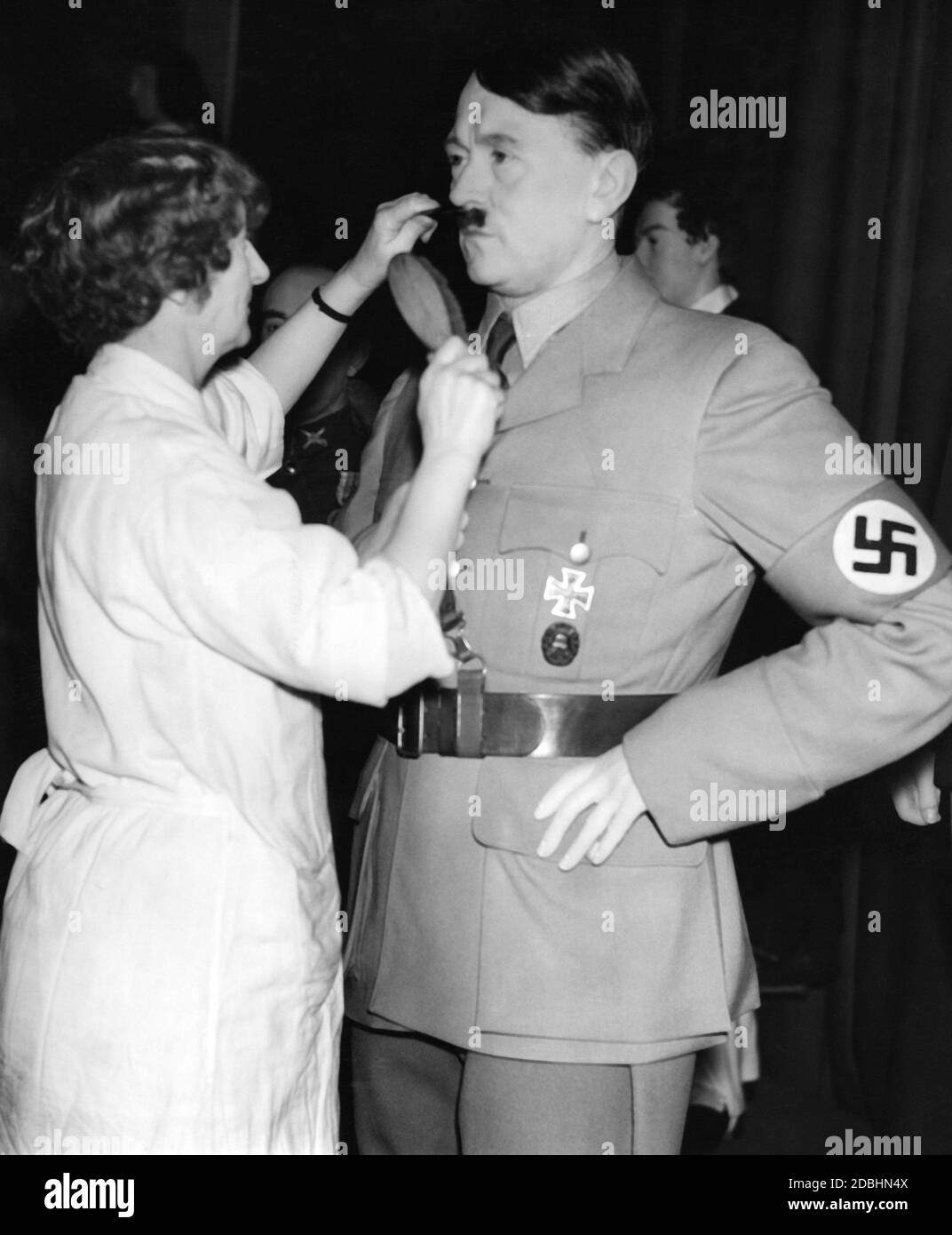 The moustache of an Adolf Hitler wax figure is being combed. Maud Collins acts as a hairdresser for the wax figures in Madame Tussauds Cabinet in London, including a figure of Adolf Hitler in party uniform. In the picture Collins is styling Hitler's moustache. Stock Photo