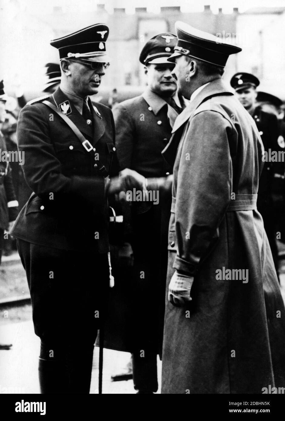 Adolf Hitler welcomes Arthur Seys-Inquart in the uniform of an SS-Gruppenfuehrer. He had received this rank as a formality after joining the NSDAP on March 13, 1938. Between them is presumably Hans Frank. Stock Photo