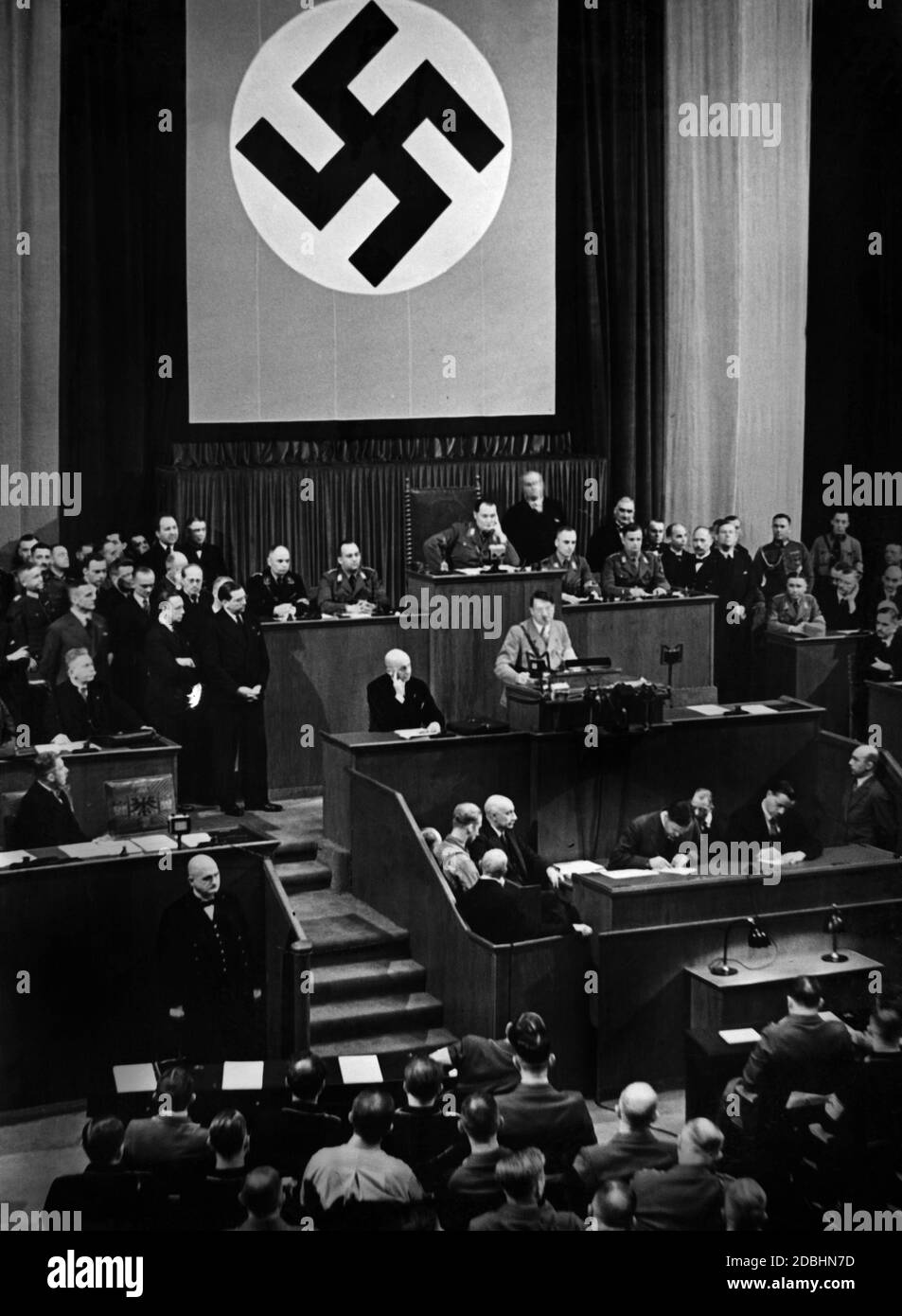 Adolf Hitler holds a speech in front of the Reichstag. On the left on the government bench, Vice Chancellor Franz von Papen is facing him and above him Hugenberg.  Hermann Goering is sitting in the presidium chair. Stock Photo