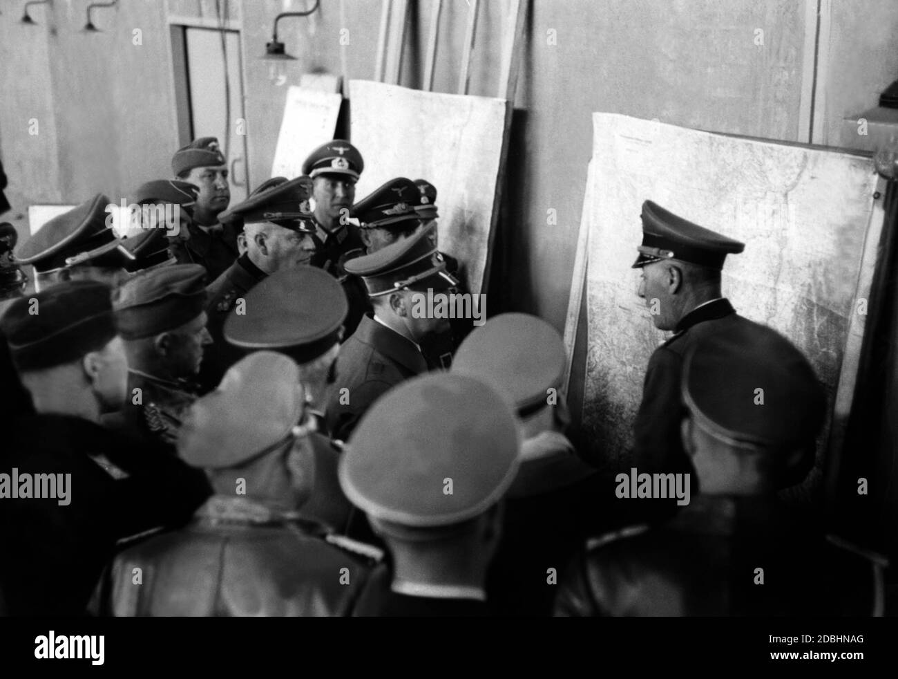 Adolf Hitler asks General Friedrich von Dollmann to explain a situation map. Behind Hitler, Wilhelm Keitel and Martin Bormann. Stock Photo