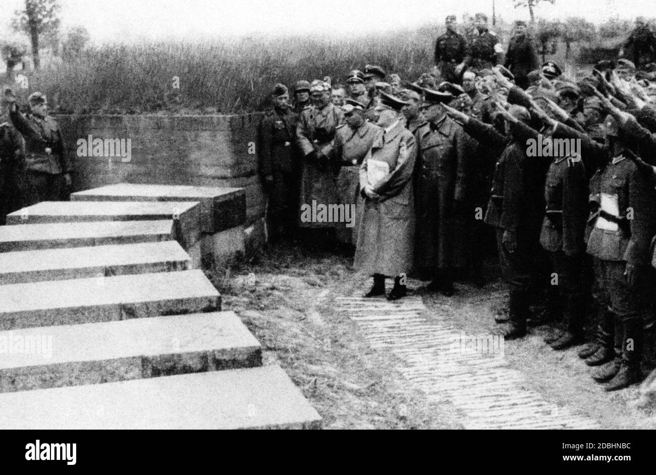 Adolf Hitler with his entourage at the military cemetery of Langemarck. Behind him is probably Werner von Brauchitsch in a leather coat. Hitler progandistically cultivated the myth of Langemarck with his visit. Stock Photo