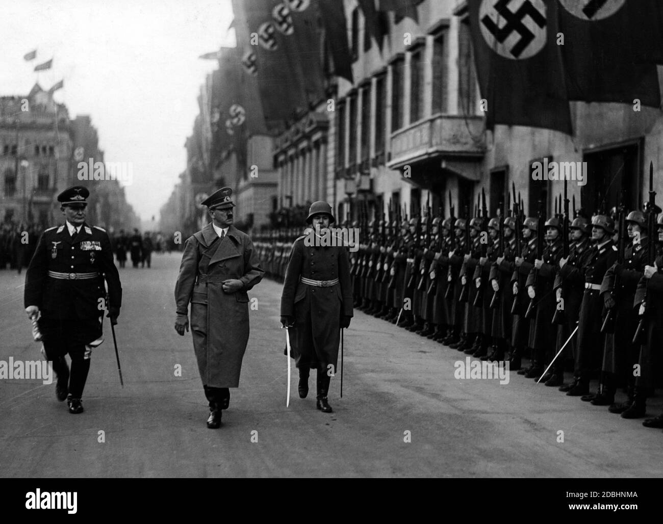 On March 16, 1938, Adolf Hitler inspects the newly formed honor company in front of the Reich Chancellery in Berlin. Left: Field Marshal Hermann Goering. Stock Photo