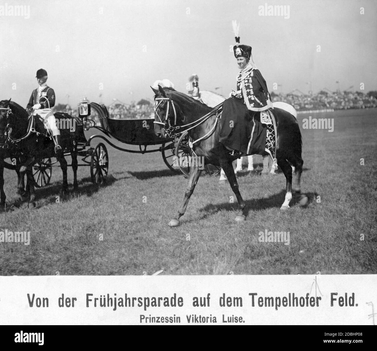 Princess Victoria Louise of Prussia (in the uniform of the 2. Leib-Husaren-Regiments „Koenigin Viktoria von Preussen“ Nr. 2) took part in the spring parade on the Tempelhofer Feld in Berlin in 1911. In the background there are tribunes with audience. Stock Photo