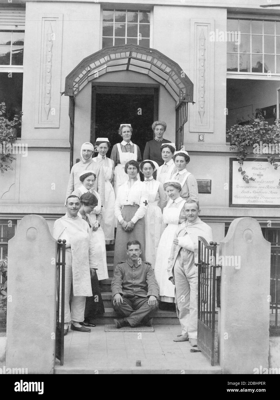 'Princess Viktoria of Schaumburg-Lippe (born of Prussia, centre of the picture with the Red Cross armband) stands with wounded and nurses in front of the entrance to the ''Glueckauf'' military hospital. The sign next to the entrance reads: ''Glueckauf. Association Hospital of the Branch Association of the Red Cross for the City and Region of Bonn and of the Patriotic Women's Association of the Region of Bonn''. Viktoria was honorary chair of the women's association and supported the hospital with her donations. The photo was taken in November 1914 after the outbreak of the First World War.' Stock Photo