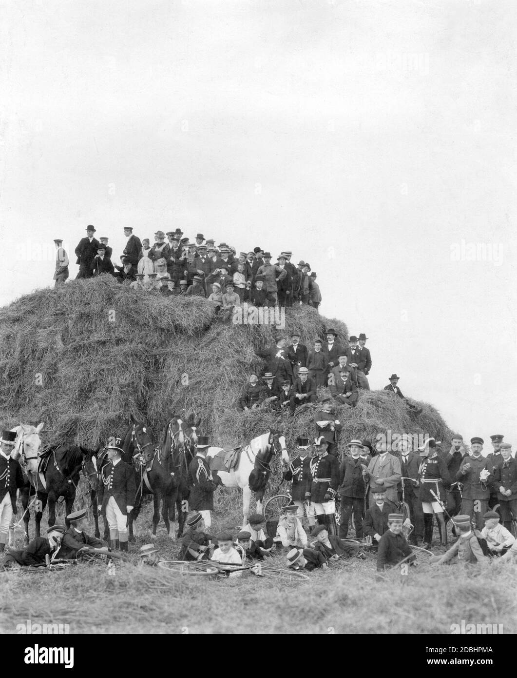 For the inhabitants of the manoeuvring area, especially the rural nobility, landowners and large farmers, the autumn manoeuvres, once the harvest had been brought in, provided a break from everyday life. The picture shows a group of away supporters during the 1904 imperial maneuvers around a large heap of straw. In the front, servants in livery hold the ladies' riding horses. Stock Photo