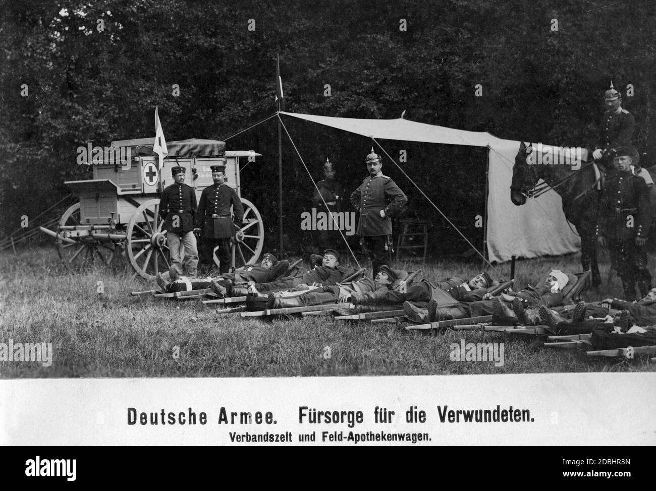 Paramedics of the German Army with wounded at a first-aid tent and field pharmacy car. Stock Photo