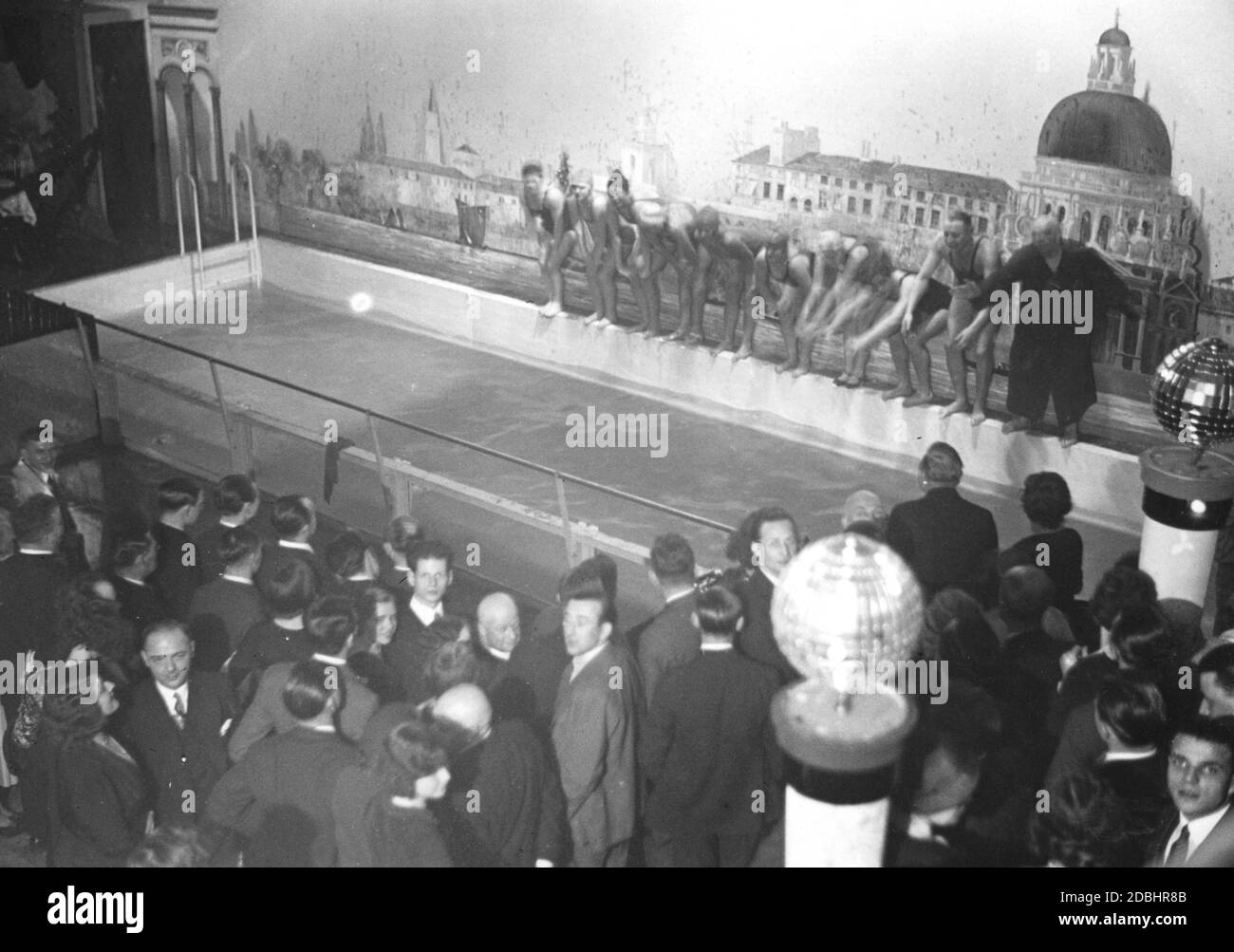 'In the new Tanzpalast (''Dance Palace'') in Berlin-Mitte, the former Altes Ballhaus in Joachimstrasse, a swimming pool was built as an attraction, from the edge of which some swimmers want to jump into the water. On the left, some guests watch from the dance floor. The trend of bathing in dance palaces was taken over from Paris. The picture was taken in 1931.' Stock Photo