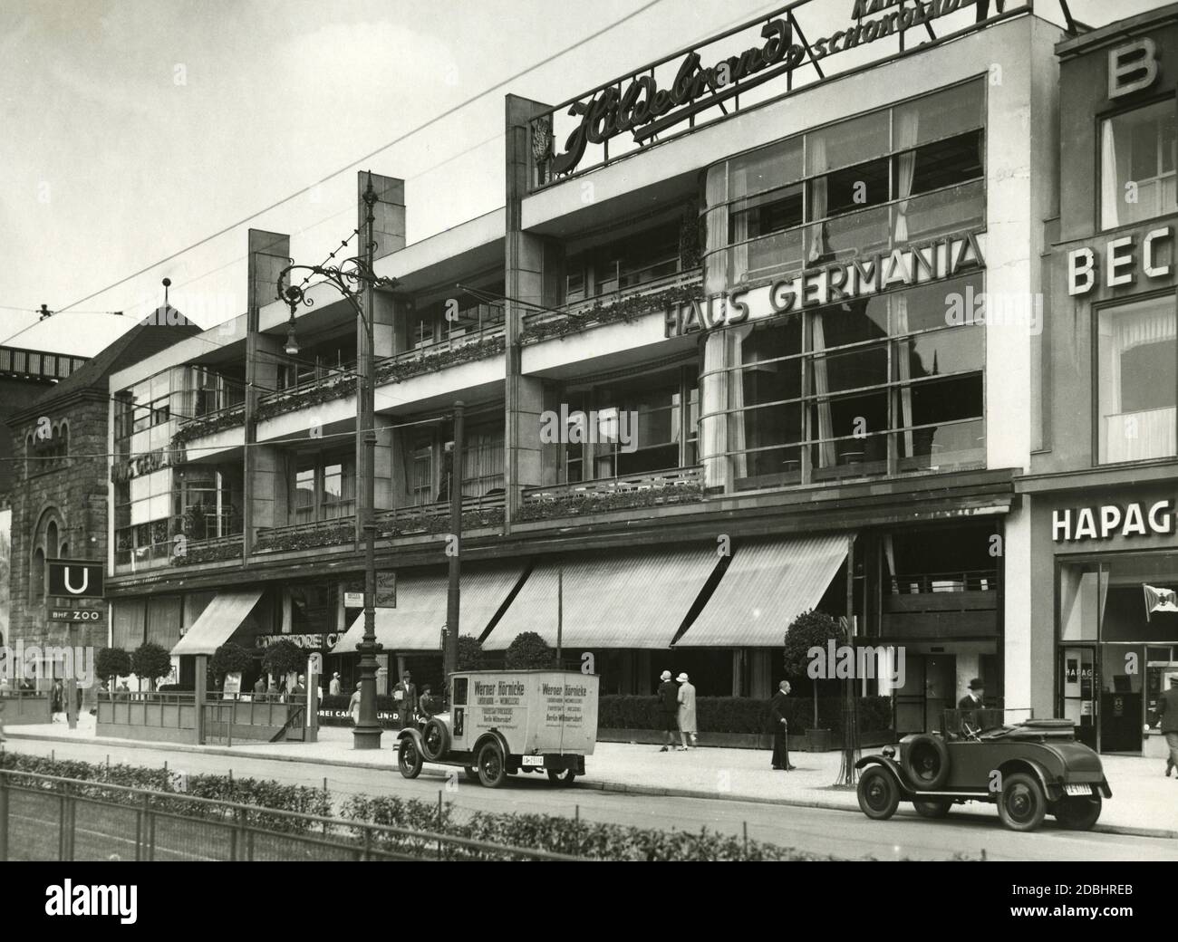 'The picture from 1930 shows the elegant and modern  Haus Germania at Hardenbergstrasse 29 in Berlin-Charlottenburg. Below were several restaurants, including the ''Conditorei Cafe Berlin''. On the roof, there is an advertisement for ''Hildebrand Kakao Schokolade''. In front of the building is a delivery van of the fruit juice press Werner Hoernicke from Berlin-Wilmersdorf.' Stock Photo