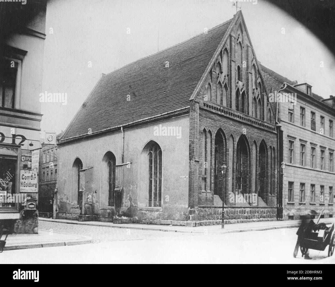 'The photo shows the Heilig-Geist-Kapelle at Spandauer Strasse, corner St. Wolfgang-Strasse in Berlin-Mitte. On a house on the left is a sign for ''Comtoir H. Goldberg''. Undated photo, taken before 1904, before the right building was demolished and replaced by the building of the Berlin School of Economics.' Stock Photo