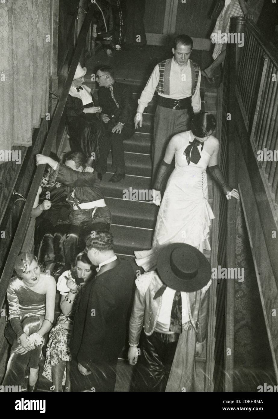 'On February 10, 1933, the Verein fuer Deutsches Kunstgewerbe in Berlin organized an artist's masquerade ball called ''Die bunte Laterne'' in the  Festraeumen des Zoo. The photograph shows couples sitting on a staircase.' Stock Photo