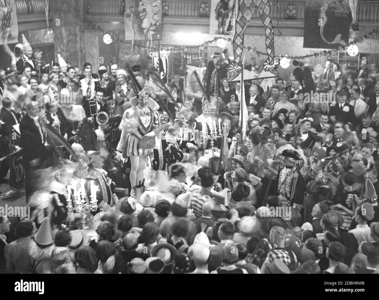 'A man personifying ''Prince Carnival'' (center, standing on the table) greets the guests of the Alaaf Carnival Ball at the Berlin Zoo with a speech. Undated photo, taken around 1935.' Stock Photo