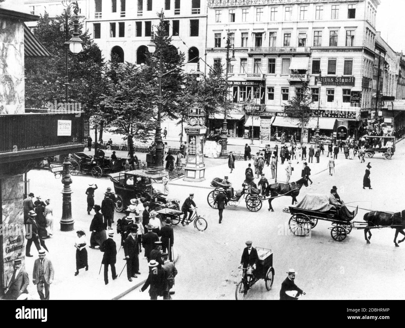 'The photograph shows the intersection of Friedrichstrasse and Unter den Linden in Berlin in 1913, filled with carts and passers-by, with numerous billboards hanging from the houses, including one that is in the middle of the street: ''Julius Staudt. Photograph'', ''Ludwig Fischer'' and ''Krueger & Oberbeck'' (tobacco shop).' Stock Photo