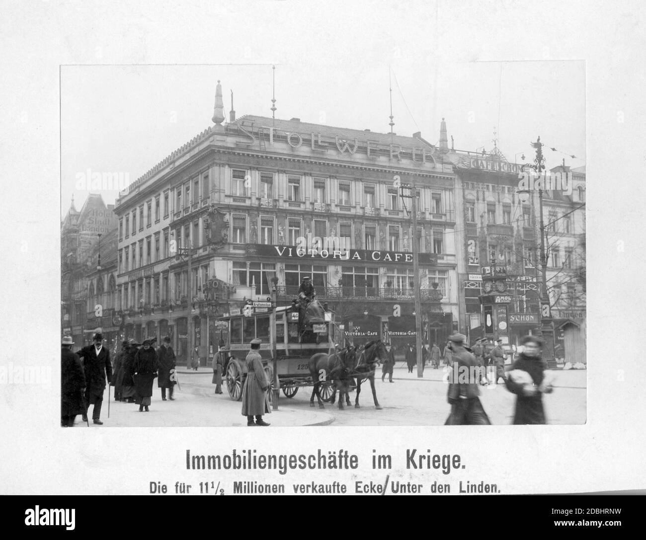 'The Hotel Victoria on the street Unter den Linden, at the corner of Friedrichstrasse in Berlin, changed owners in 1916. The hotel housed the Victoria-Cafe, and next to it the Cafe Schoen. On the roof of the hotel there is an advertisement for ''Stollwerck'' ( chocolate brand). Down on the street a carriage stops at a motor bus stop.' Stock Photo