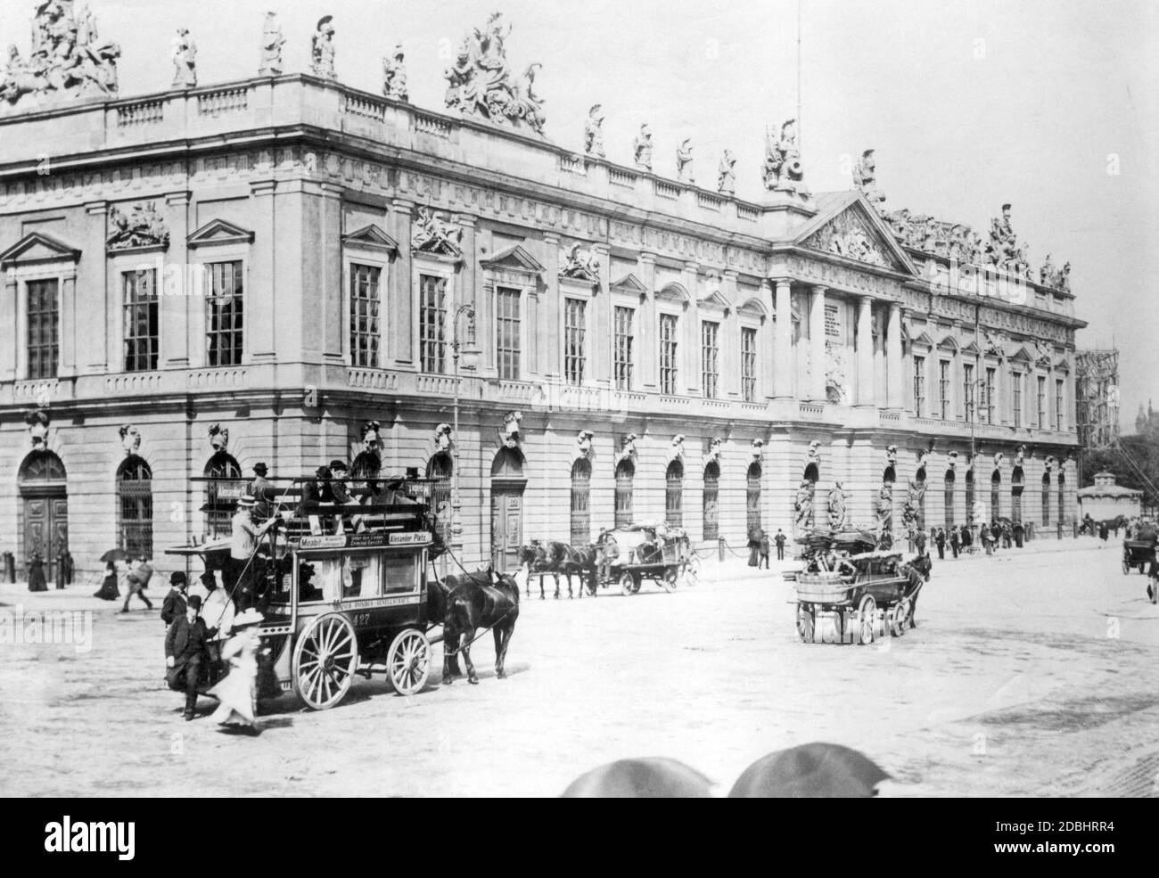 'The photo shows carts and a horse-drawn omnibus on the street Unter den Linden in Berlin in front of the Zeughaus. The bus of Omnibus-Gesellschaft drives from Moabit via the street Unter den Linden and the ''Criminal Court'' to Alexanderplatz. The picture was taken around 1900.' Stock Photo