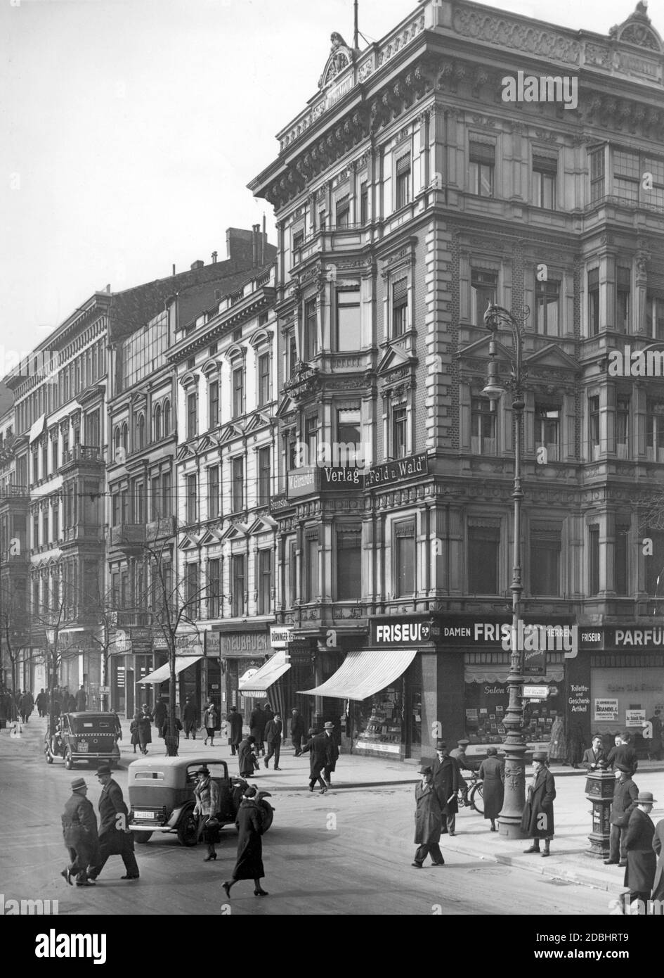 'The picture shows the block of houses at Unter den Linden 59a - 63, corner Neustaedtische Kirchstrasse, in Berlin in 1935 before its demolition. The buildings had to make way for the construction site for the tunnel of the North-South S-Bahn, which was led further north from the Unter den Linden station (today: Brandenburg Gate). The photo shows numerous stores including a ladies' hairdresser, the publishing house ''W. Girardet'' and the store ''Duerninger Zigarren Herrnhut''.' Stock Photo