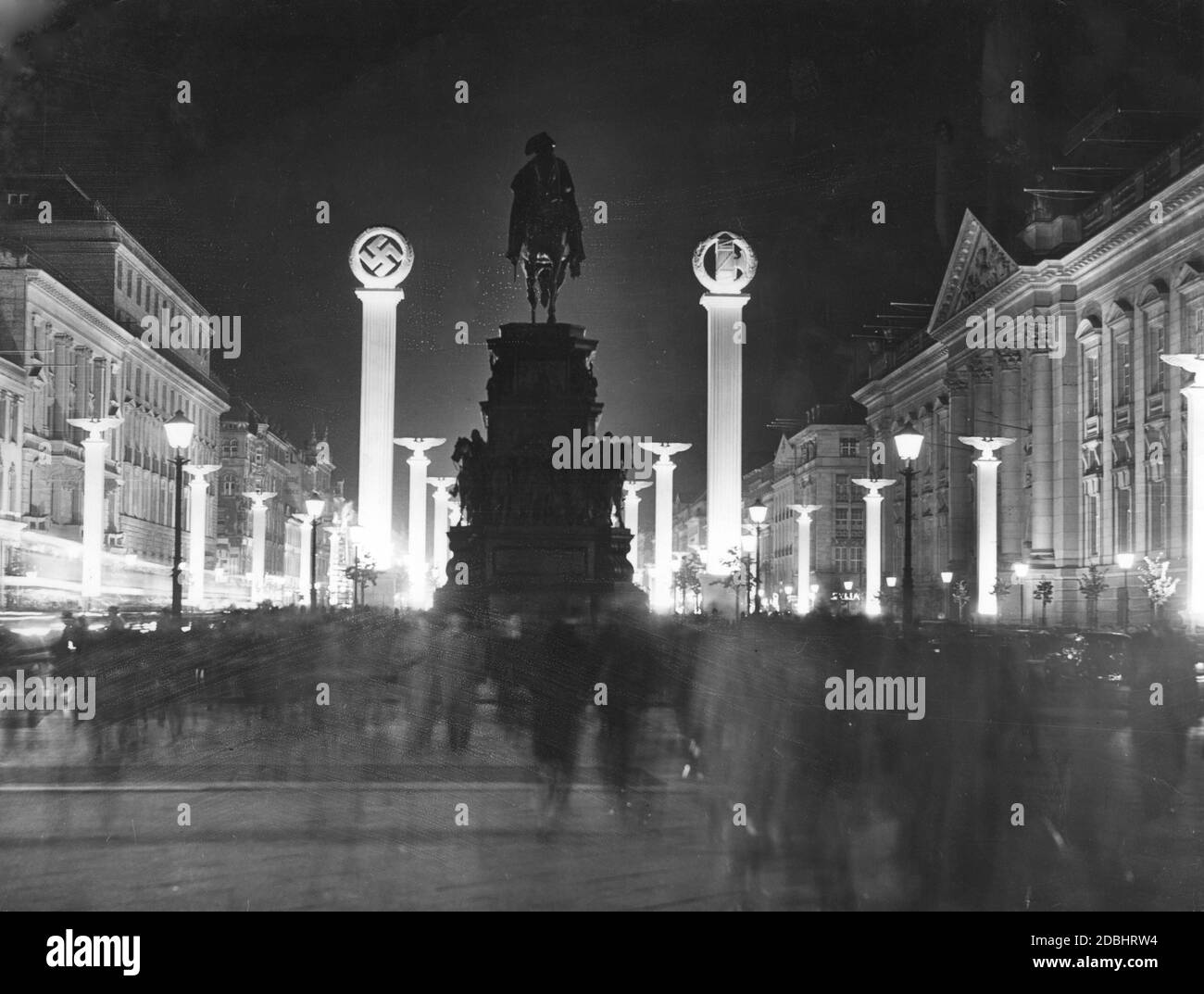 Benito Mussolini visited Germany between September 25 and 29, 1937. The picture shows the test illumination of the columns with Nazi symbols in the street Unter den Linden in Berlin before the visit of the Duce. The equestrian statue of Frederick the Great stands out in darkness. On the right is the Staatsbibliothek. Stock Photo