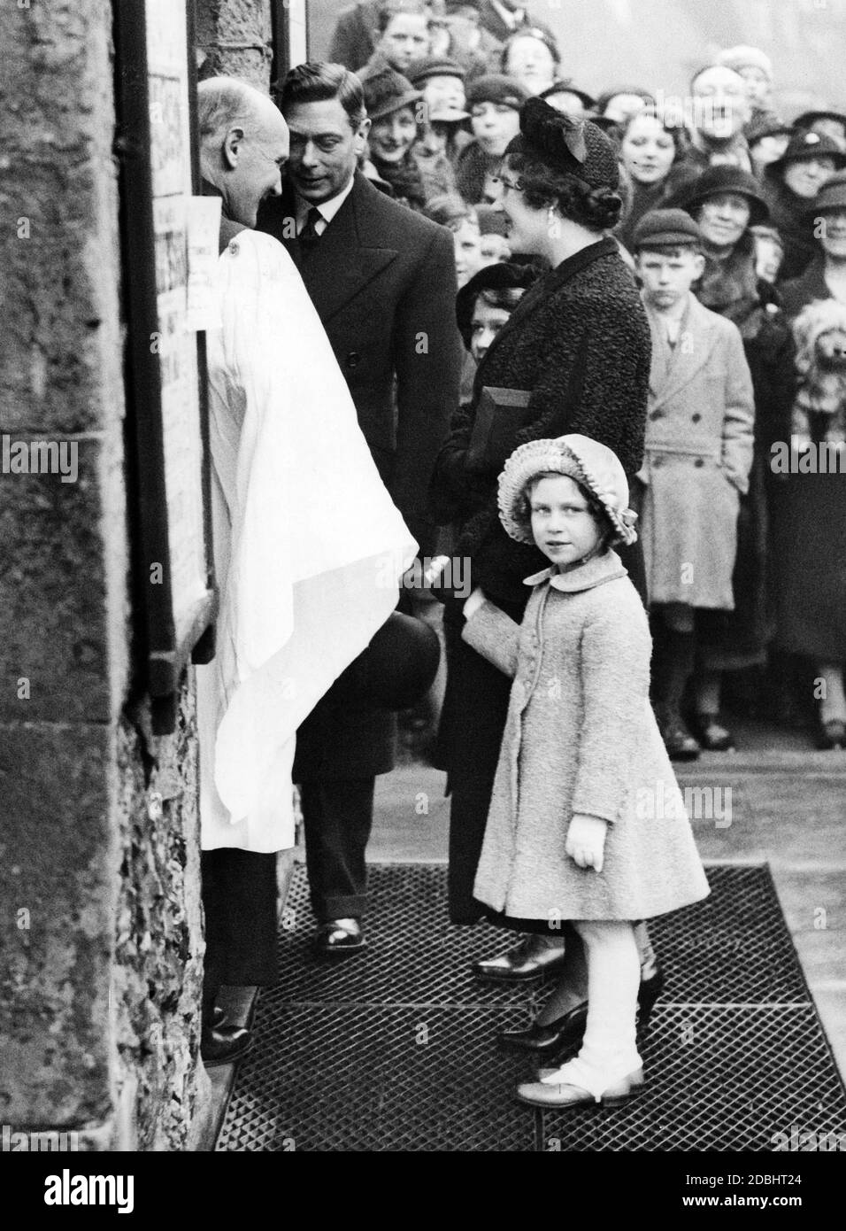 Princess Margaret with her mother Elizabeth Bowes-Lyon and her father George VI. in fornt of St. Mary's Church in Eastbourne. Reverend F.P. Hughes welcomes them. Stock Photo
