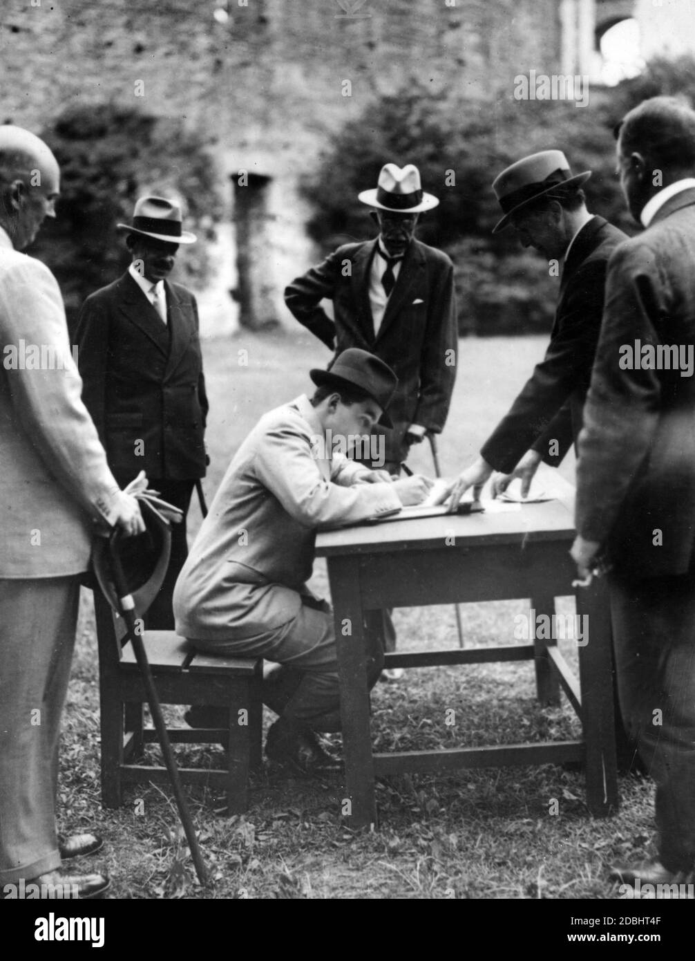 Otto von Habsburg signs the guest book during a visit to the summer residence of the Swedish king. Behind him is King Gustav V of Sweden. Stock Photo