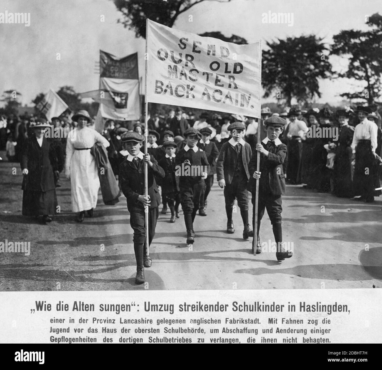 Schoolchildren march with posters in front of the High School Authority building in the factory town of Haslingden in the county of Lancashire in northern England. Stock Photo