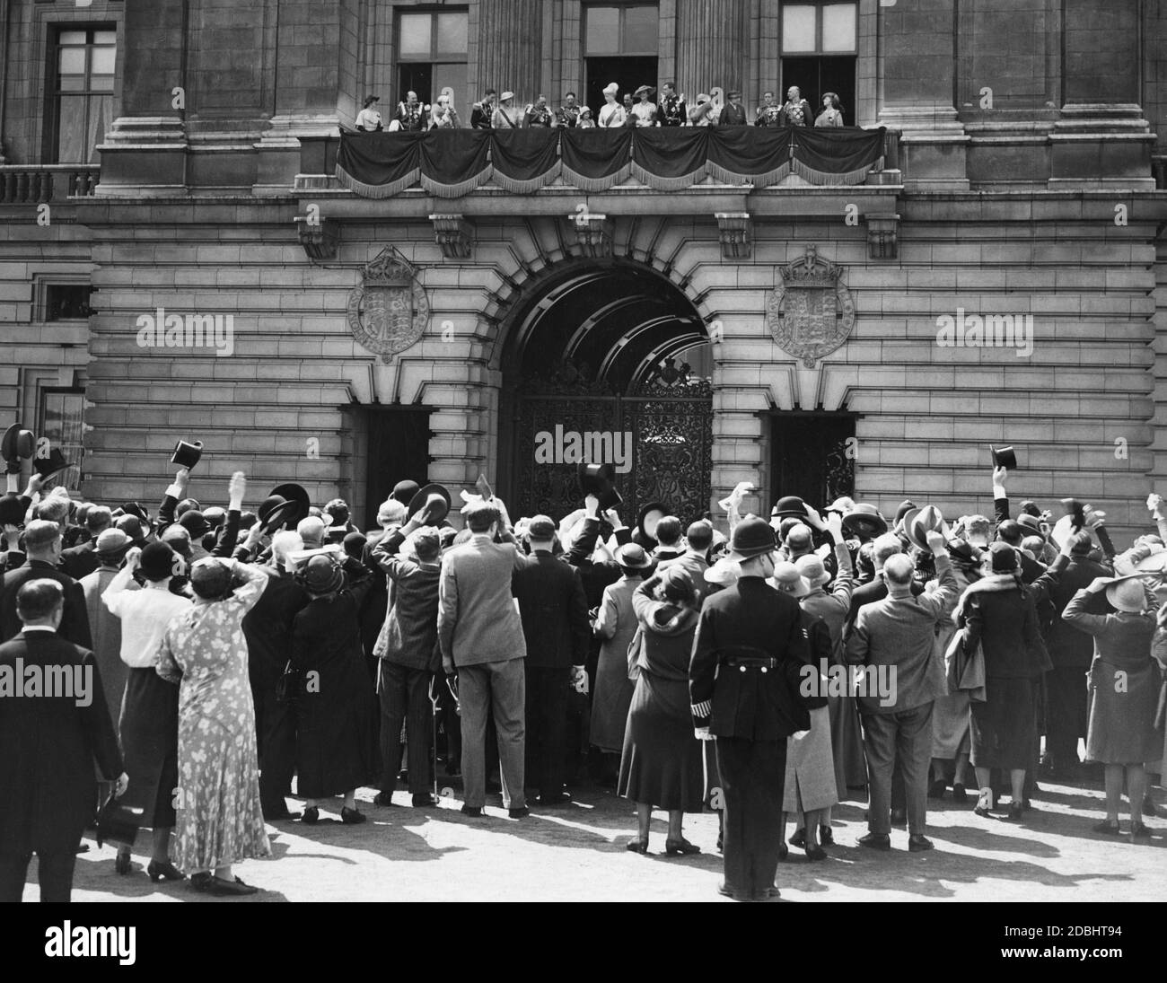 A crowd cheers King George V and his family on the balcony of Buckingham Palace after their return from St. Paul's on the occasion of the celebration of his 25th throne anniversary. Stock Photo