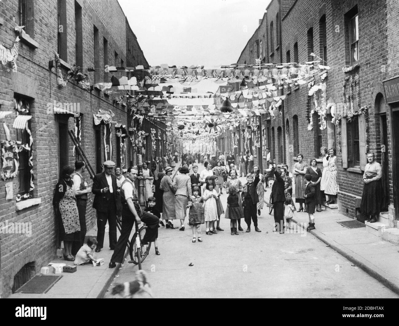 The festively decorated Heath Street in Stepney in honor of the 25th anniversary of the accession of King George V to the throne. On this day the King visited the poorer parts of London. Stock Photo