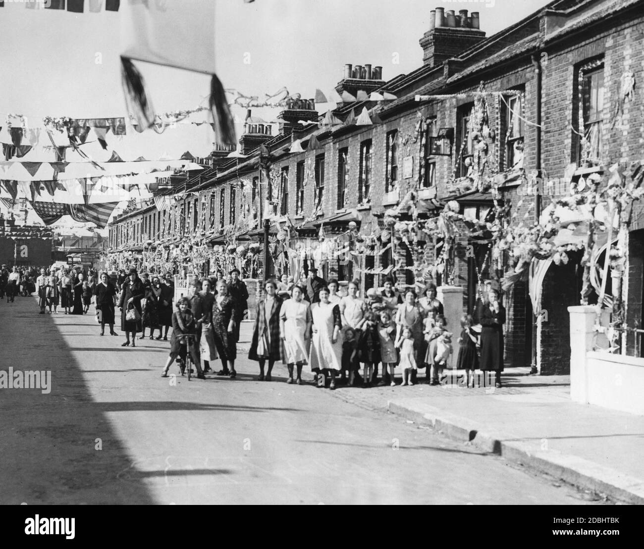 Festively decorated street in South London in honor of the 25th throne anniversary of King George V. On this day the King visited the poorer districts of Lambeth, Battersea and Wendsworth. Stock Photo