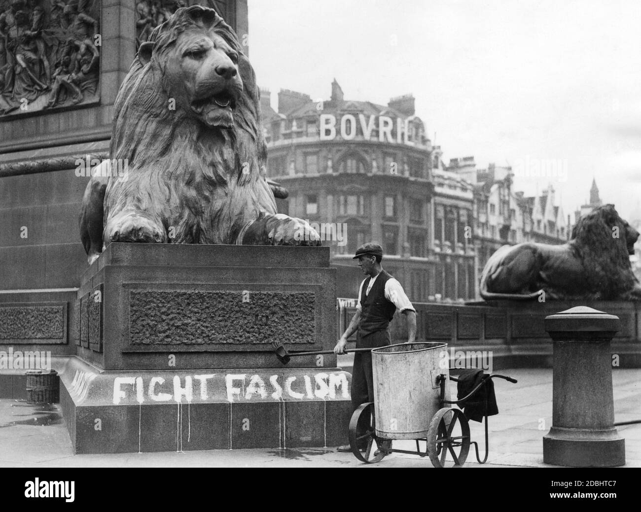 'A worker removes an anti-fascist slogan (''Fight Fascism'') from the base of the Nelson Column in Trafalgar Square in London.' Stock Photo