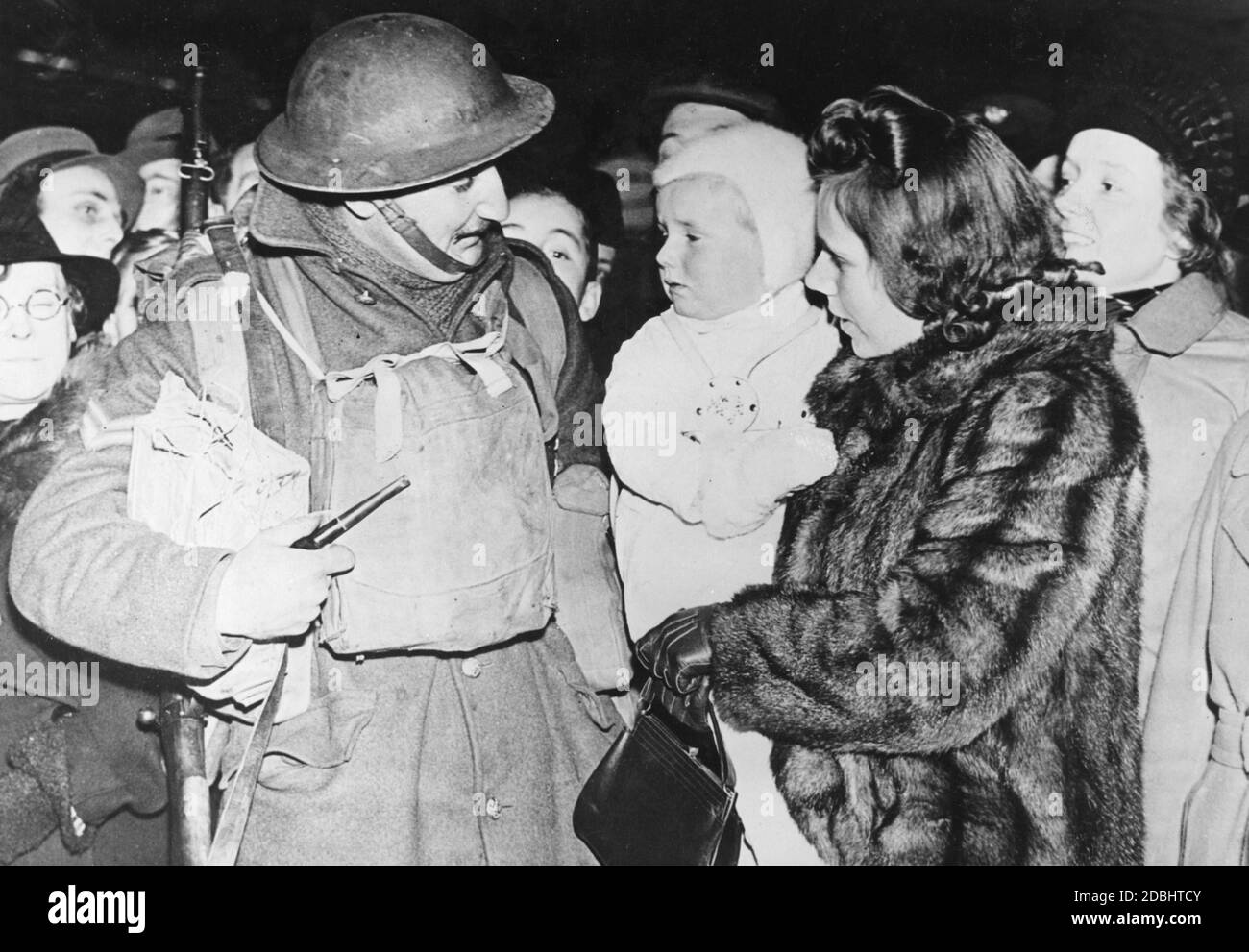 An English infantry soldier on furlough greets his family. Stock Photo