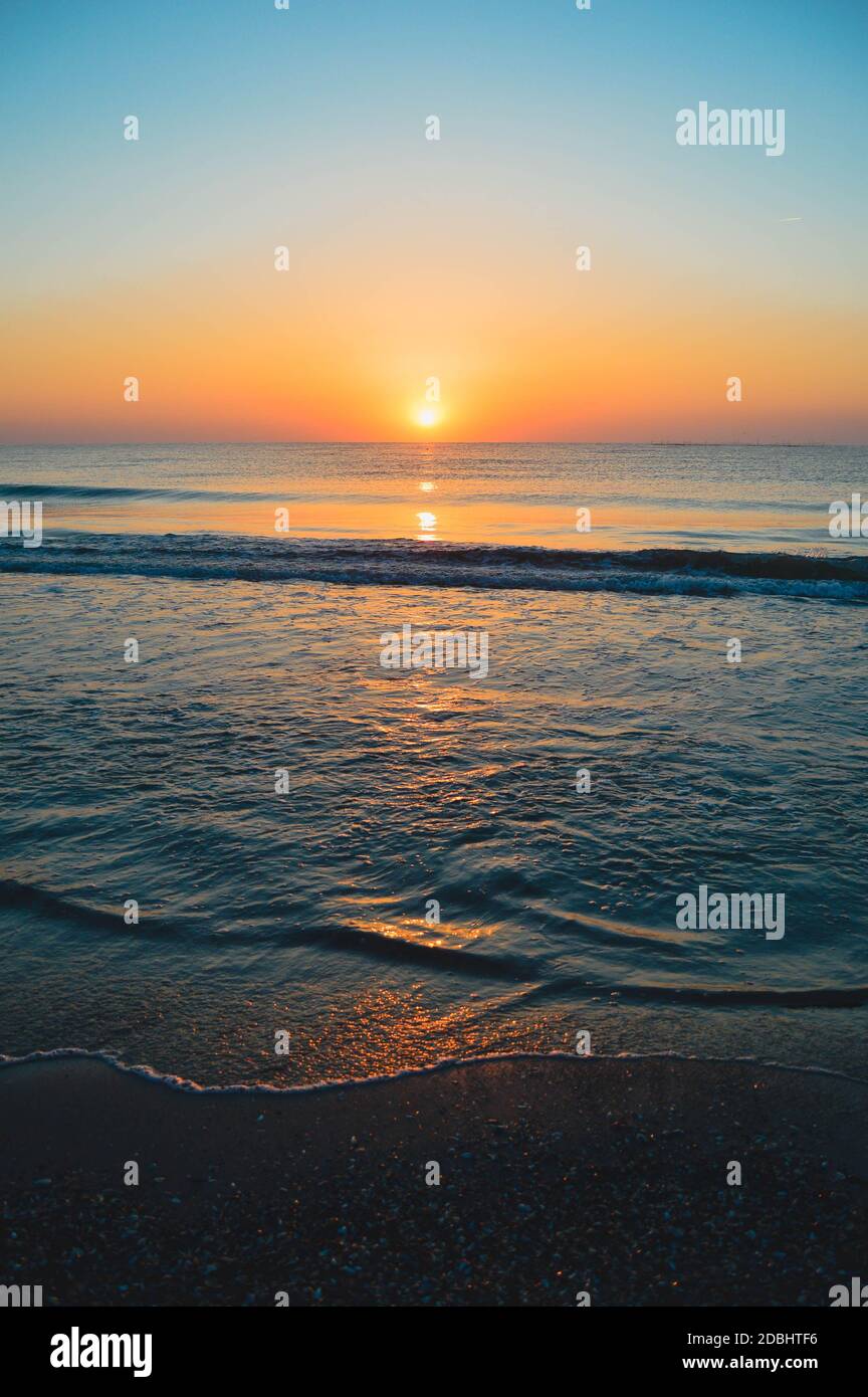 Beautiful summer landscape, sunset at the beach, sparkly sand and waves ...