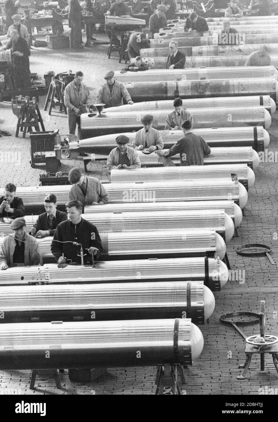 Workers involved in the production of torpedoes in a British armaments factory. Stock Photo