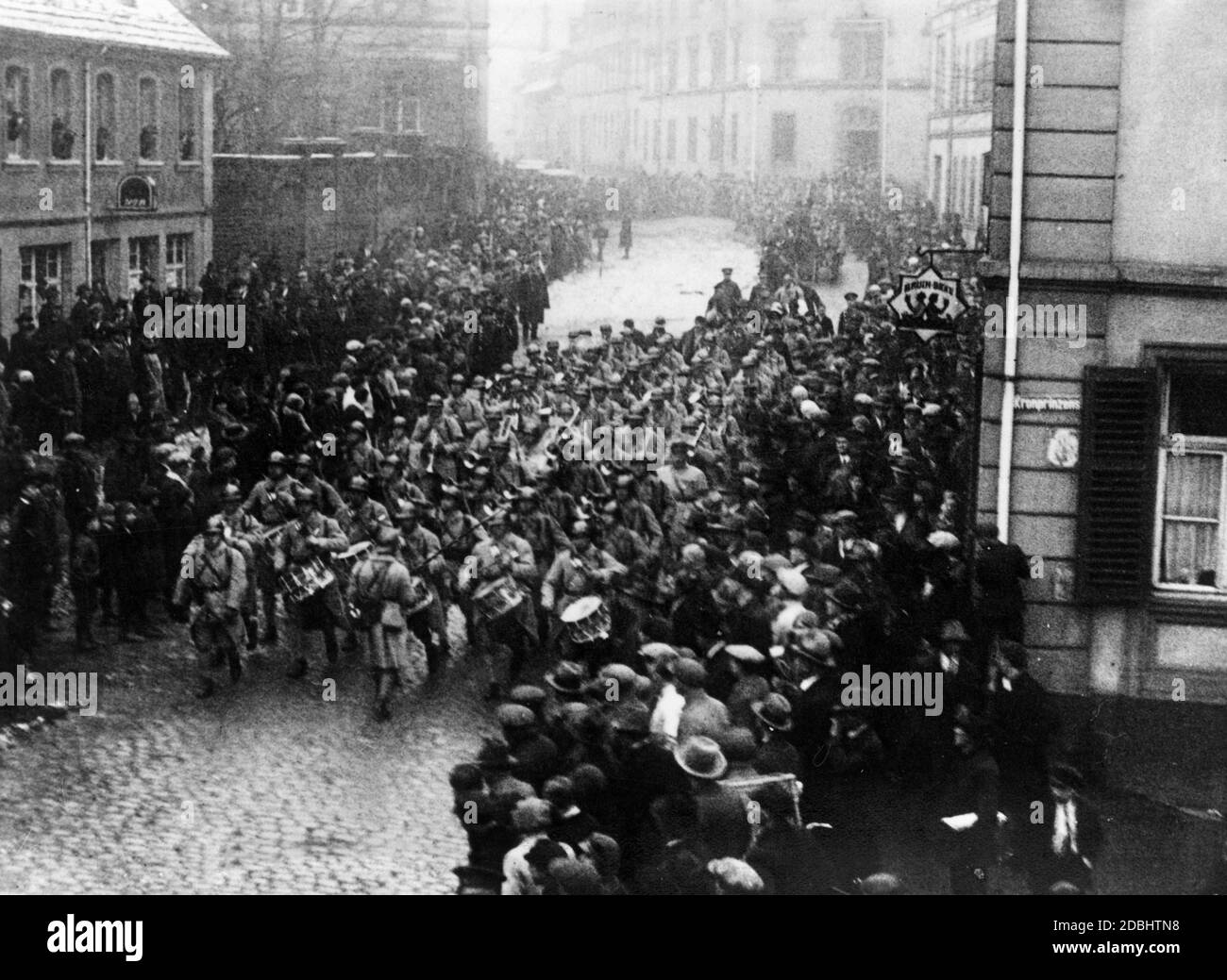 A troop of the French Railway Guard in Saarland march drumming through the old town of Saarbruecken before they leave the Saar area. At the corner to Kronprinzenstrasse there is an inn. Stock Photo