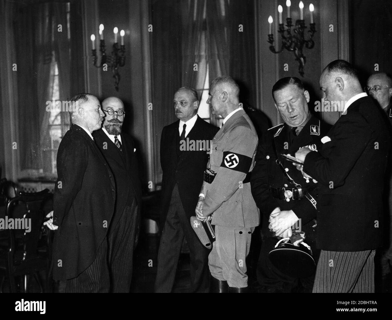 Reich Minister of the Interior Wilhelm Frick (centre in party uniform) is having a conversation with members of the League of Nations Commission in the Kreisstaendehaus in Saarbruecken, at the celebrations marking the transfer of the Saar region to the German Reich. Stock Photo