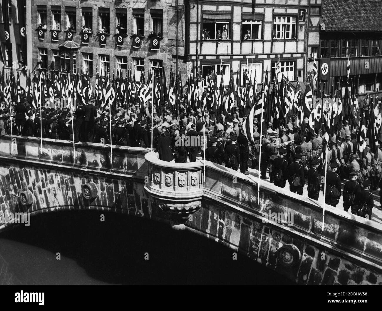 View of the flag parade of the National Socialist organizations during the Nazi Party Congress in Nuremberg on the Fleisch Bridge over the Pegnitz. Stock Photo