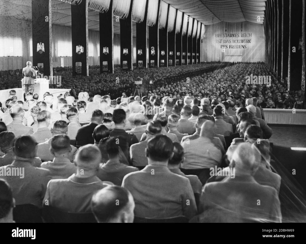 'Gauleiter Julius Streicher gives a speech at the opening of the Nuremberg Rally in the Luitpoldhalle on the Nazi Party Rally Grounds. On the opposite wall is written the slogan: ''A strong Reich is the bulwark of peace''.' Stock Photo