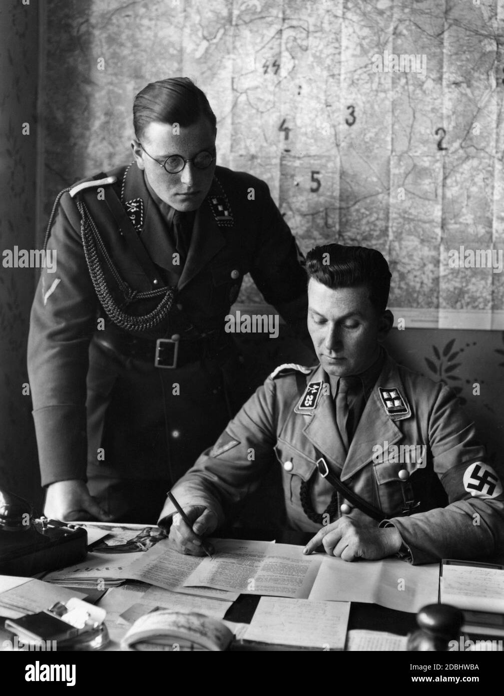 Obersturmbannfuehrer ( lieutenant colonel) v.d. Becke (r) working at his desk in Berlin. He is the leader of the SA Reiterstandarte 25. To his left is an SA Obersturmfuehrer (first lieutenant). Stock Photo