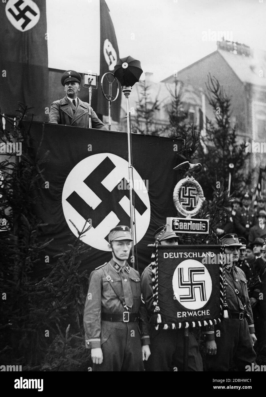 Reich Minister Dr. Wilhelm Frick gives a speech during the ceremonial name change from Saarlouis to Saarlautern. Members of the SA Brigade 30 are standing in front of the lectern and hold the standard of Saarlouis. Stock Photo