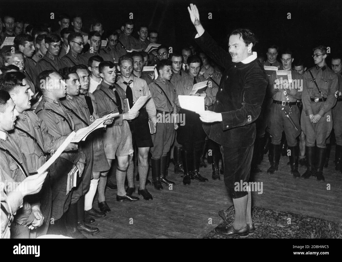 'Young SA men sing together at the Theater Friedrich des Grossen in the Neues Palais in Potsdam. The conductor of the choir is Dr. Hensel Janiczek. They are singing at the first Reichssingwoche (''Reich Singing Week''). The event is organized by the National Socialist organization ''Strength Through Joy'' and the German Student Union.' Stock Photo