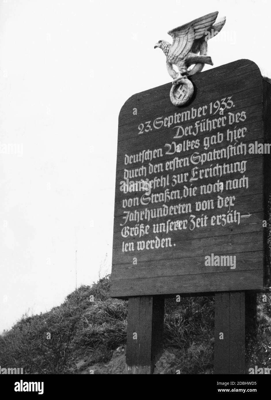 'Signboard with the inscription: ''The Fuehrer of the German people gave the order to build roads here with the first cut of the spade, which will remind of the greatness of our time even after centuries''.' Stock Photo