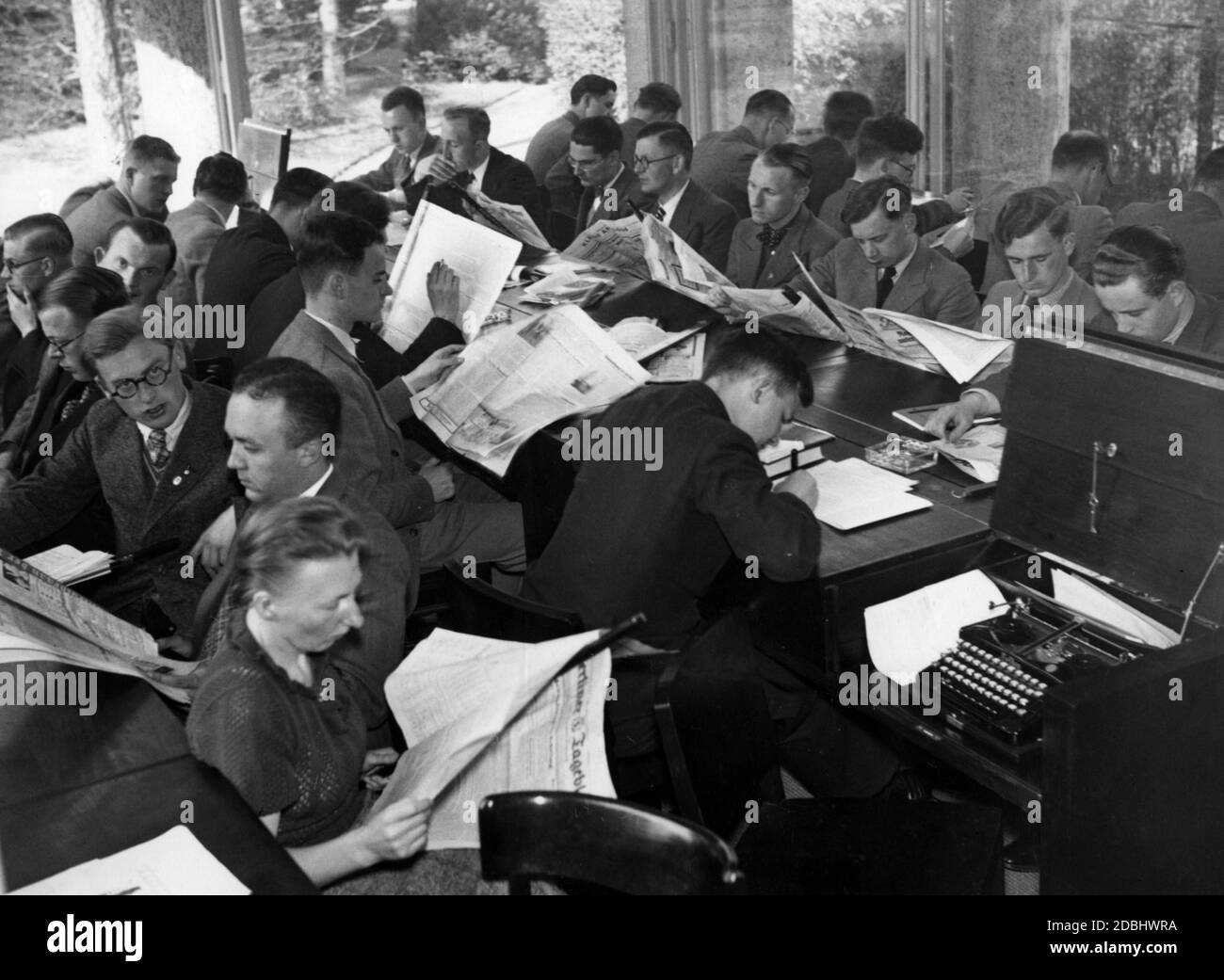 At the Reichspresseschule (Reich Press School), which opened in Berlin-Dahlem on 24 April 1936, a wide variety of German and foreign newspapers are read during working hours, including the Berliner Tageblatt. The typewriters for written work can be placed in the desks. Stock Photo