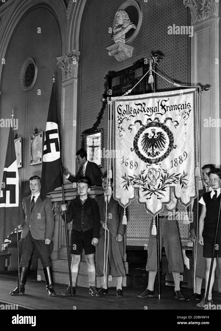 At the beginning of the school year pupils are holding school flags in the Franzoesischen Gymnasium on Reichstagsufer. Beside the swastika flags there is the flag for the 200th anniversary of the College Royal Francais 1689-1889. Above is a bust of the Great Elector Friedrich Wilhelm von Brandenburg. Stock Photo