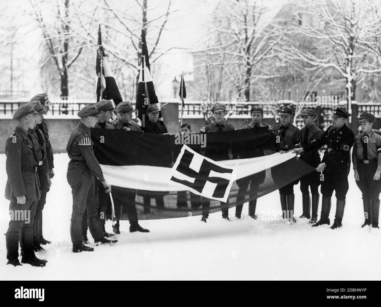 The Realgymnasium in Lichtenrade is the first school in Berlin to receive an HJ flag, as over 90% of the pupils are members of the HJ. The flag may be raised at all ceremonies. On the right in SS uniform stands the headmaster of the school Dr. Koeditz. Stock Photo