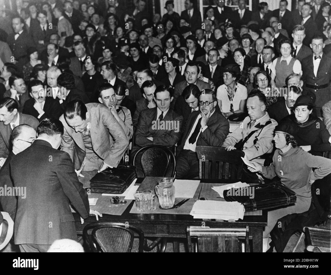 View into the courtroom of the Hunterdon County Court in Flemington, New Jersey, during the trial of the kidnapping and murder of Augustus Lindbergh. Standing on the right, bent over the table, the lawyer C. Lloyd Fisher, sitting the defendant Bruno Richard Hauptmann, to his right Loeb Barry, Sheriff, and on the far right lawyer Egbert Rosecrans. In the foreground on the right Mrs. Hauptmann. Stock Photo