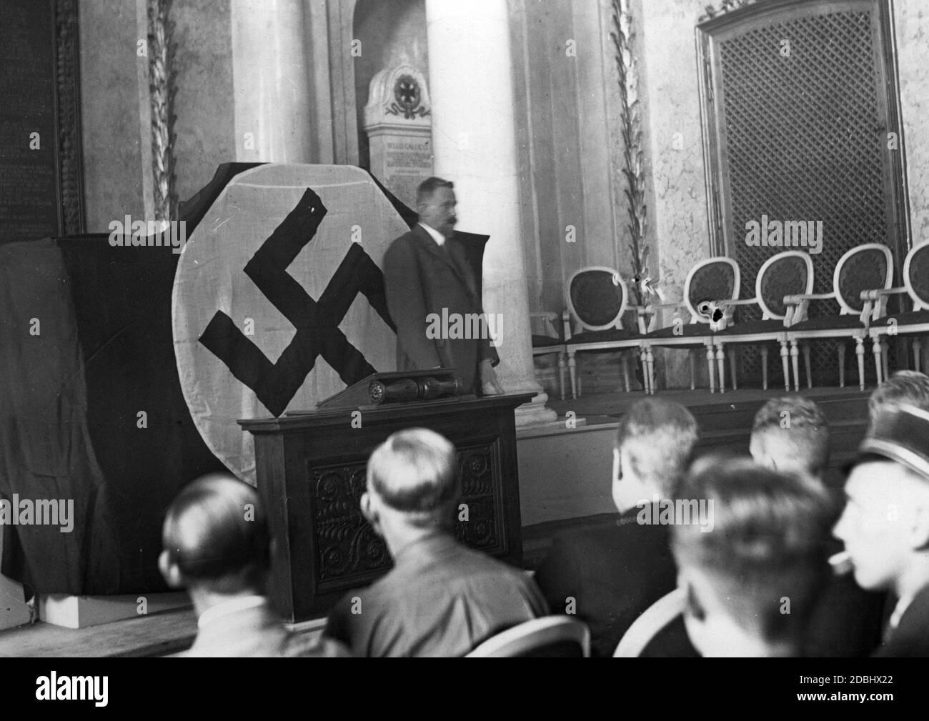 Professor Eugen Fischer, Rector of the Friedrich Wilhelm University Berlin, gives a speech in front of a swastika flag at the opening ceremony of the Buendische Kammer der Studentenschaft. Stock Photo