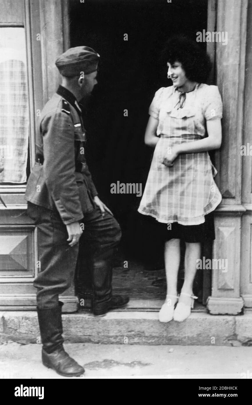 A German soldier converses with a French landlady. Stock Photo